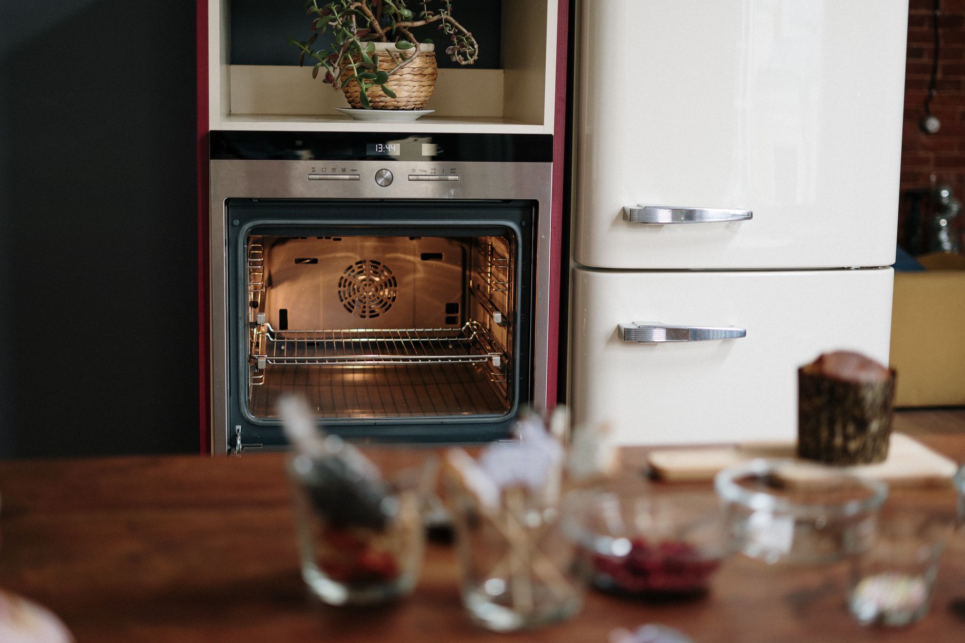 A kitchen with a wall oven beside a cream refrigerator