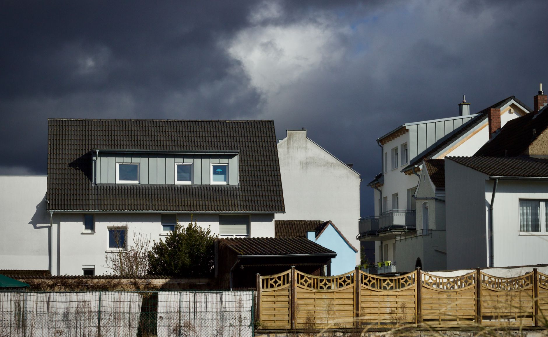 Dark storm clouds over a row of houses