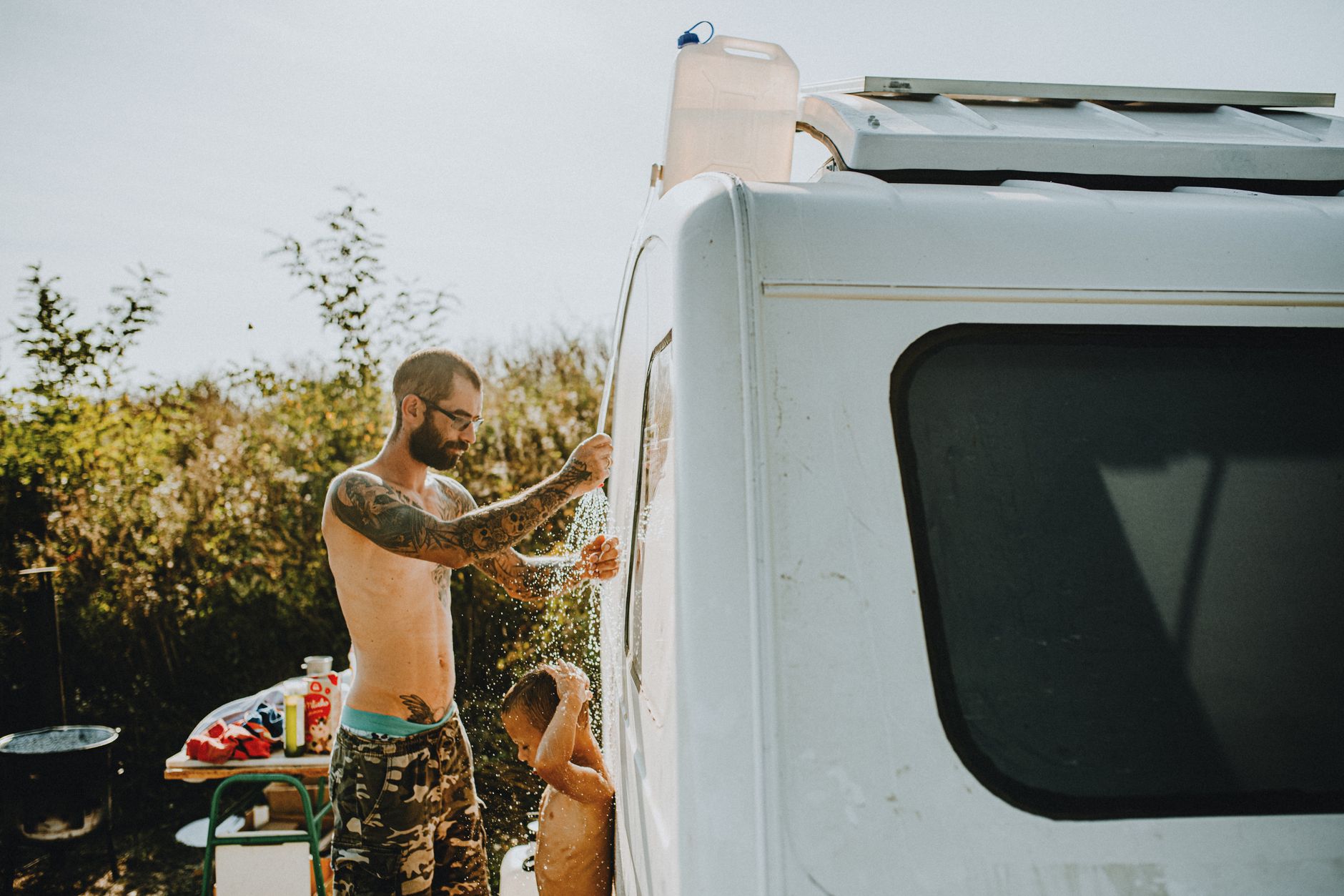 Best portable propane water heater: showering beside a camper van