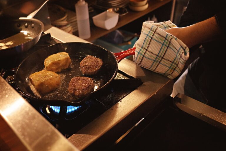 Best pot holders: a cook holding a hot pan with a pot holder