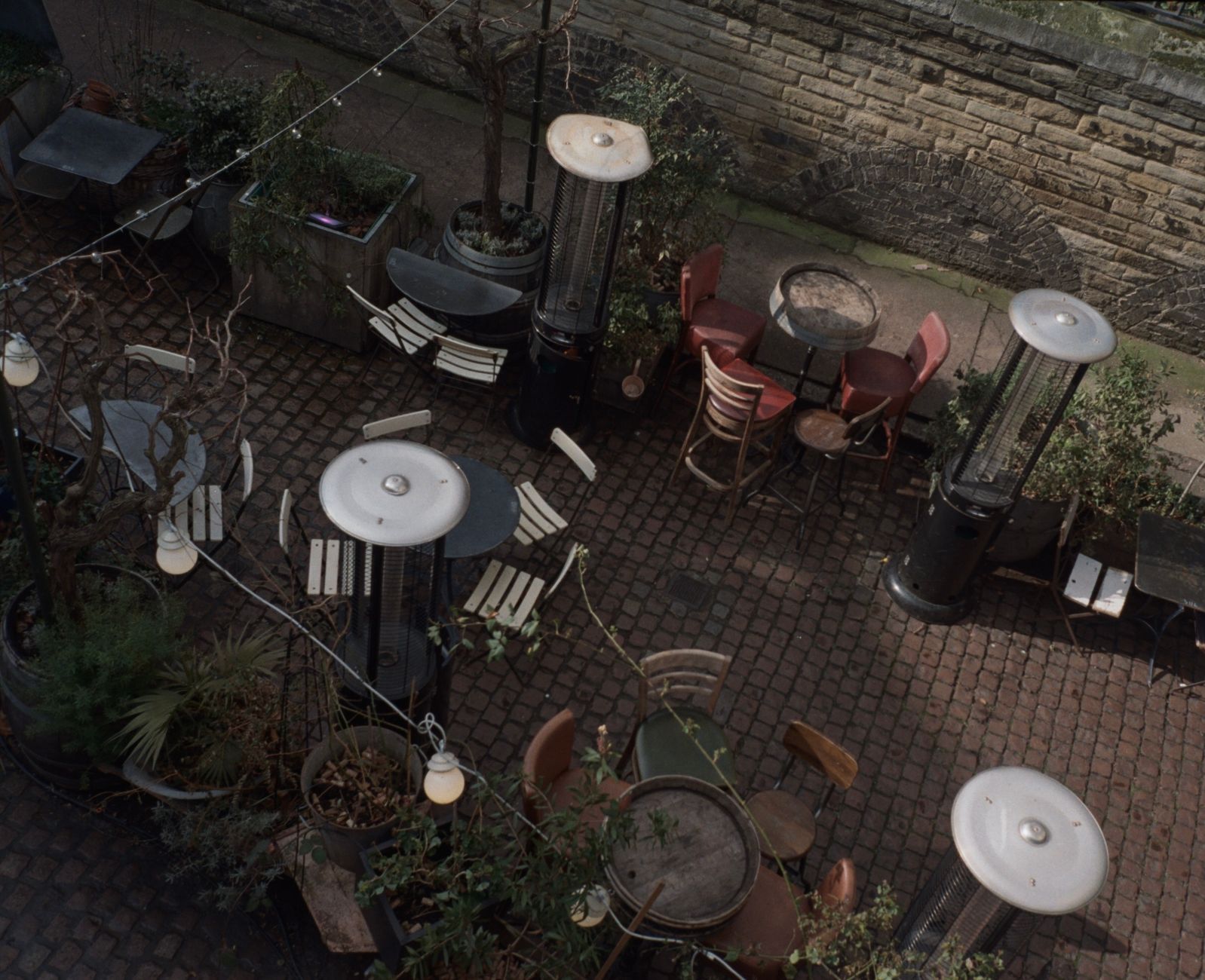 An outdoor patio with tables and heaters