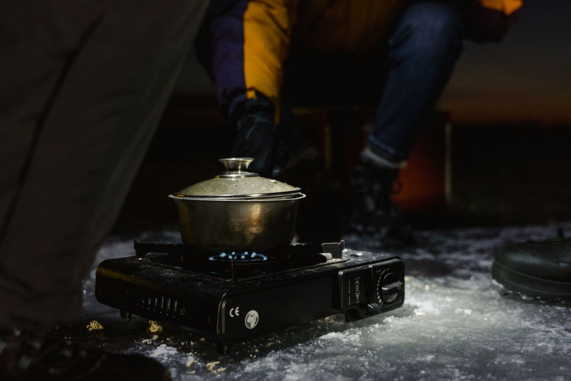 A pot on a portable gas stove at night