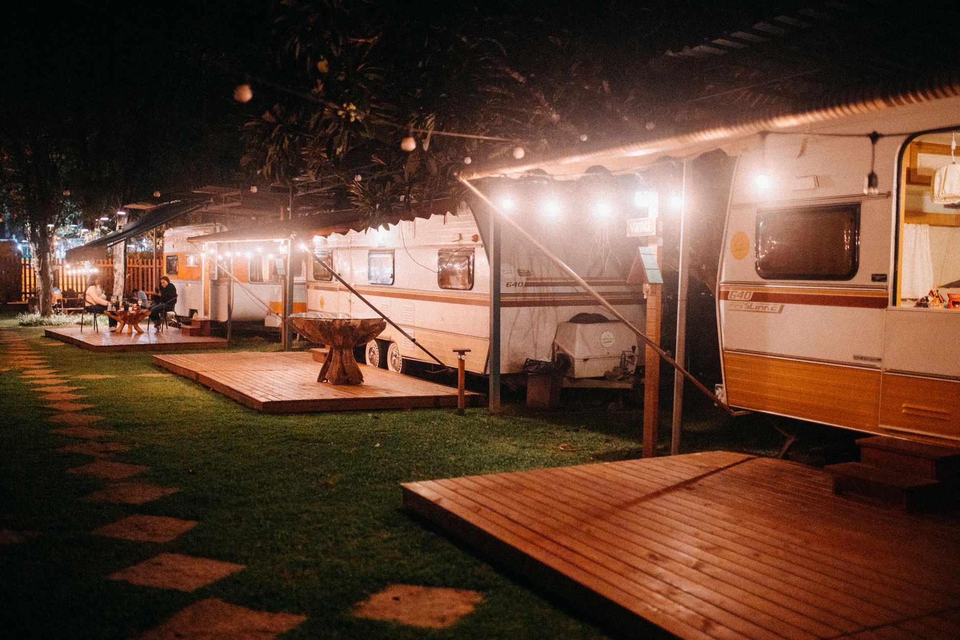Camper trailers with string lights and decks