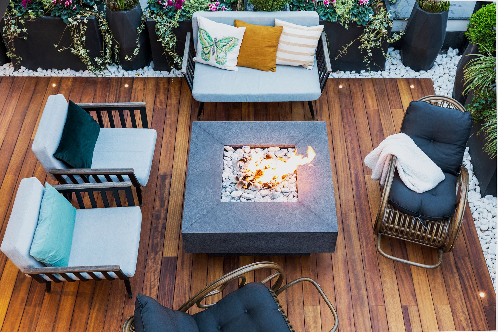 A gas fire table surrounded by patio chairs
