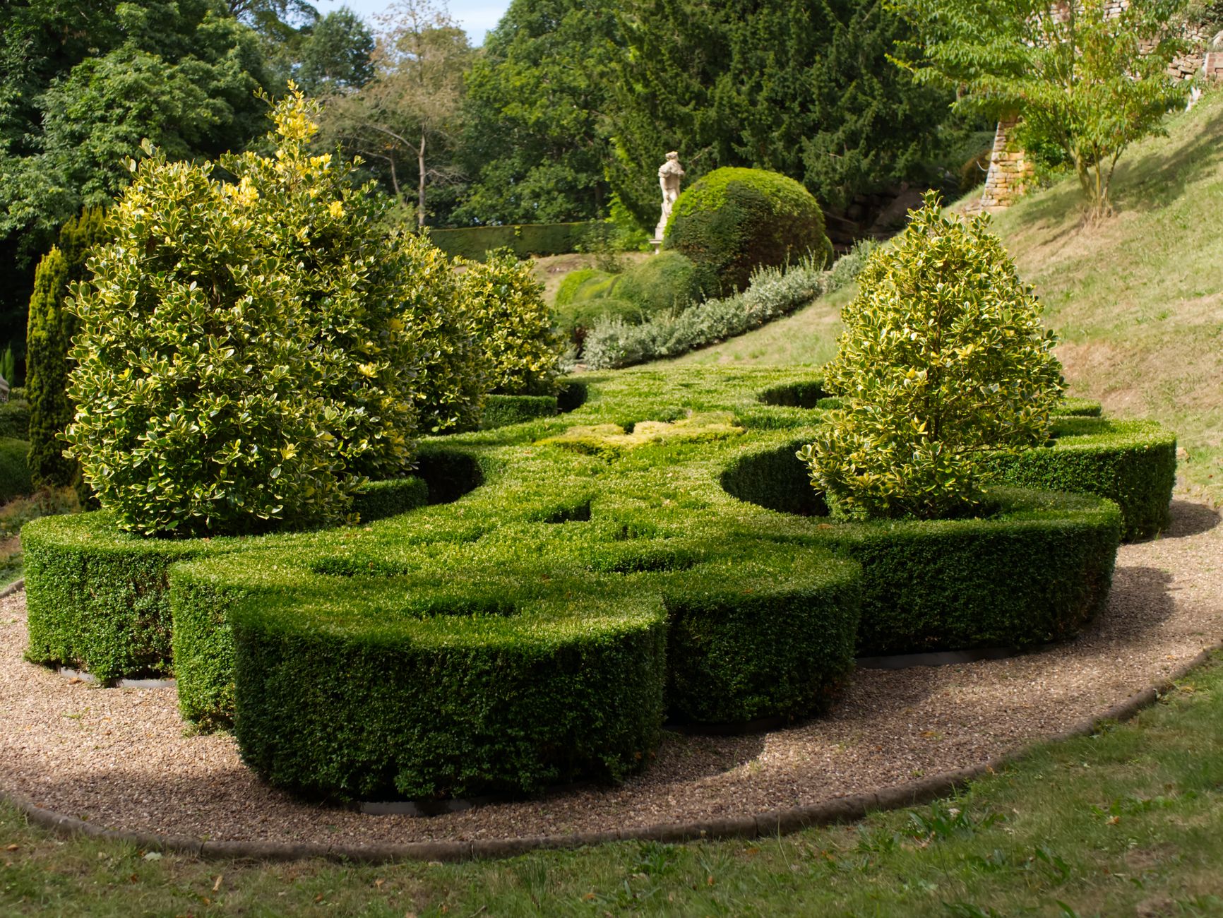 A gardener trimming shrubs in a home garden