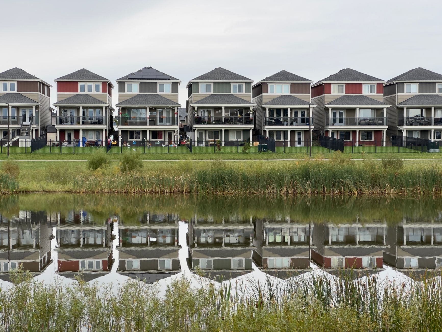 A row of houses by a pond