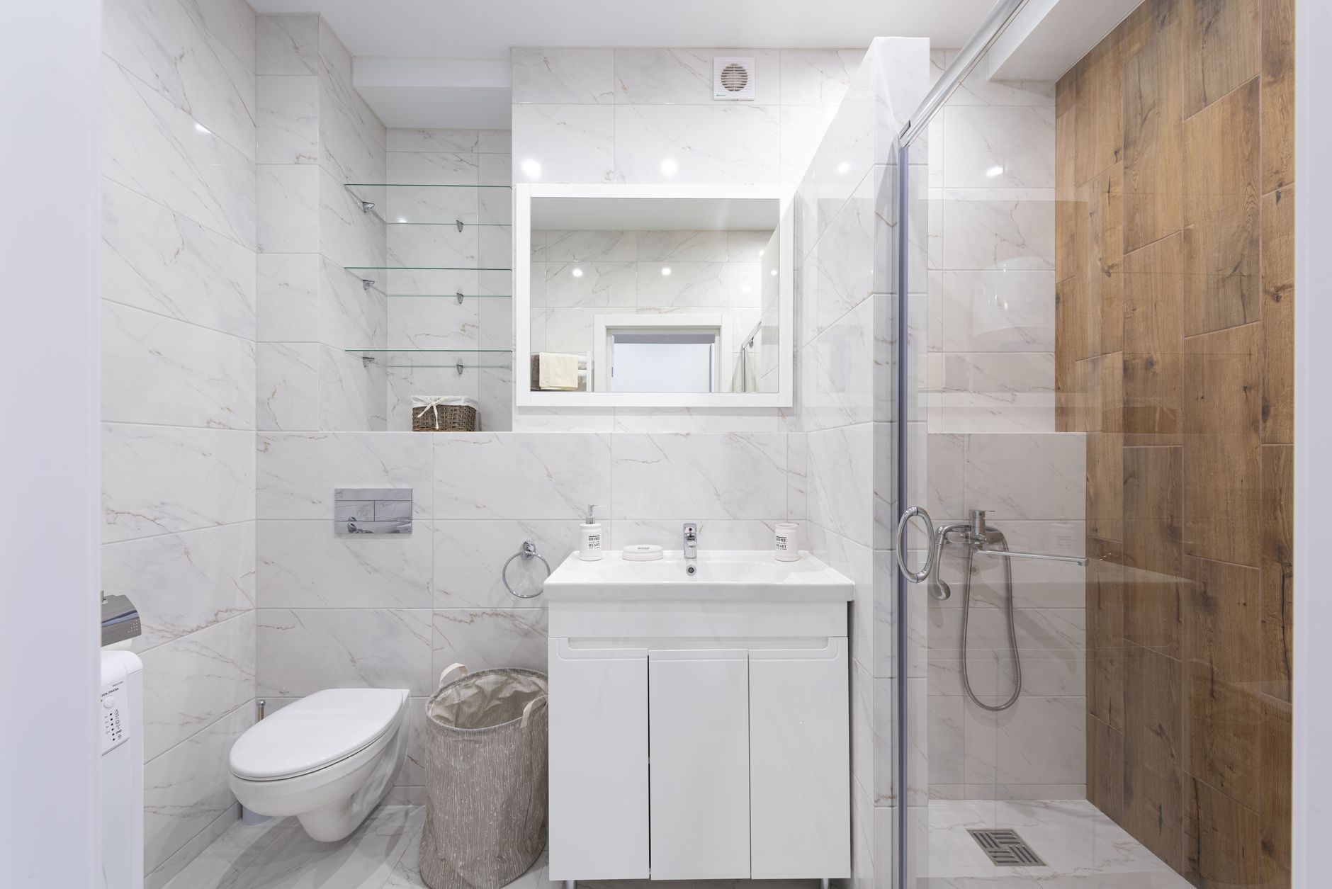 A modern bathroom with a toilet, vanity and shower