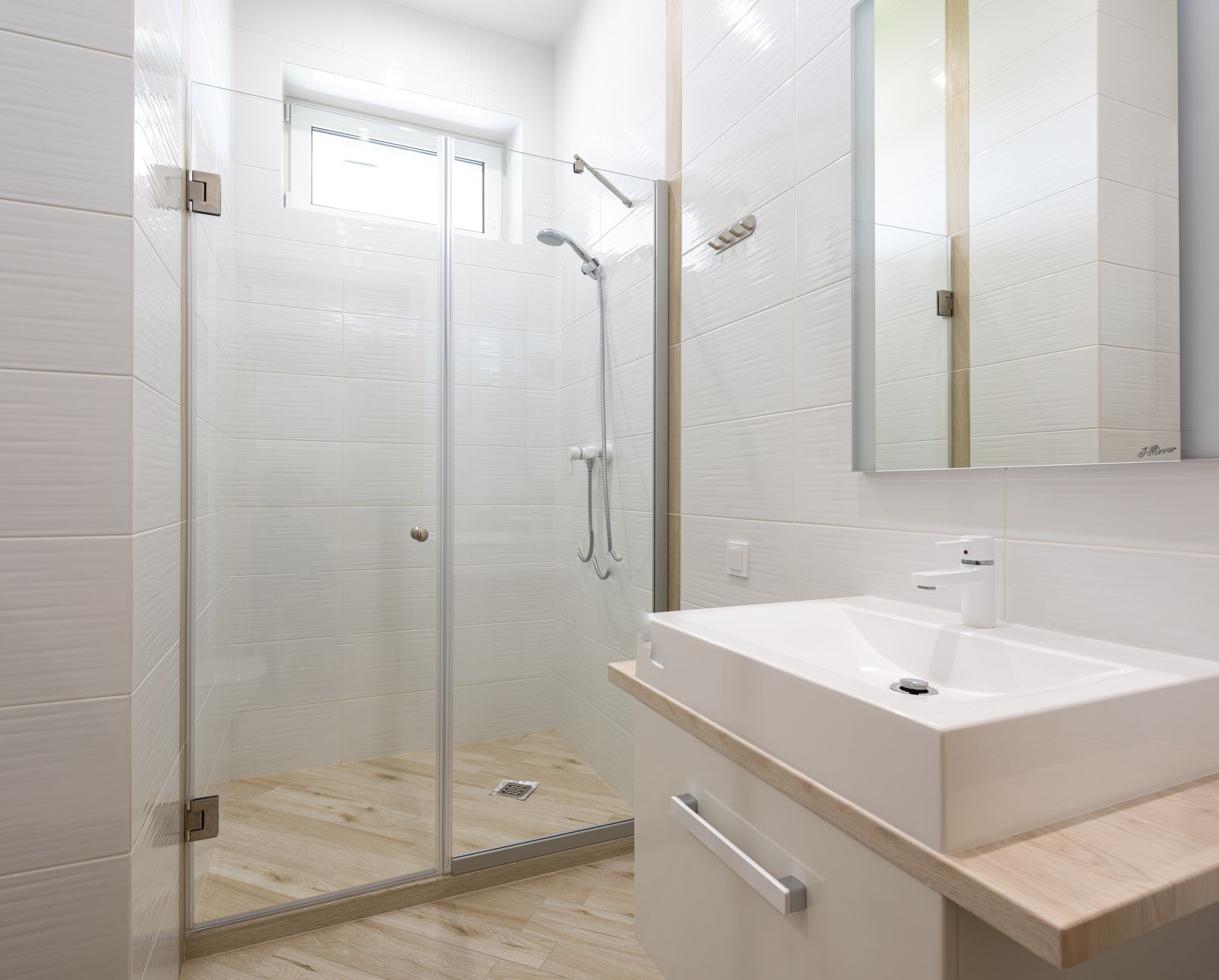 A glass shower beside a bathroom sink