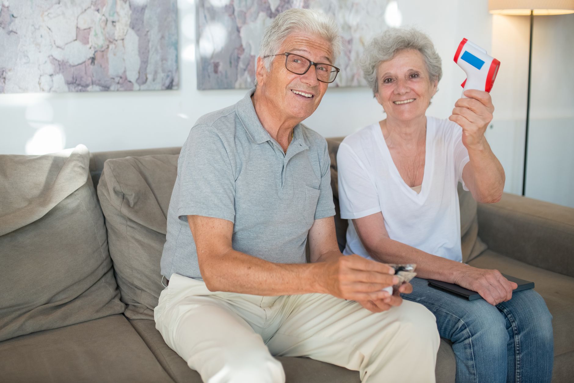An older couple smiling on a sofa