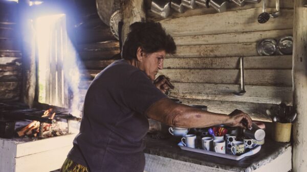 A woman setting out cups in a rustic kitchen