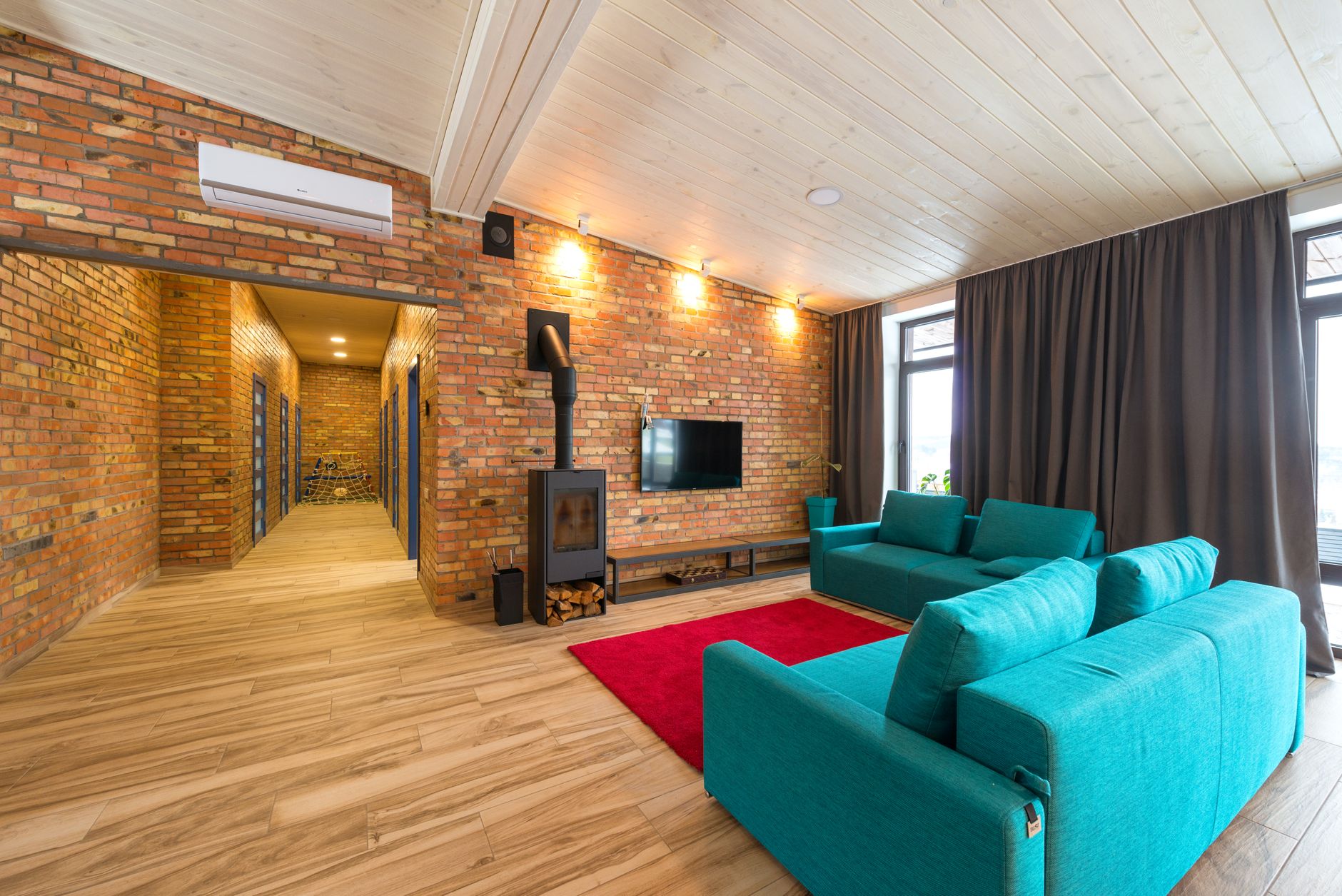 A living room with teal sofas and a wood stove