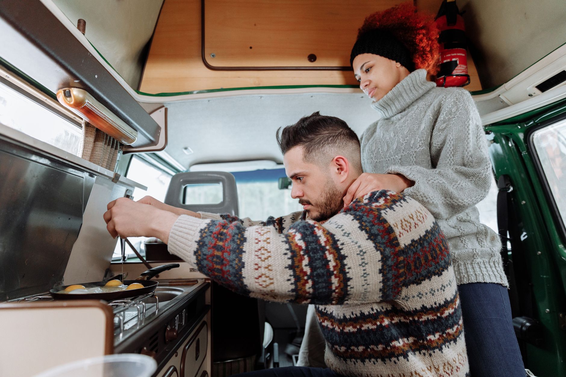 A couple cooking in a camper van