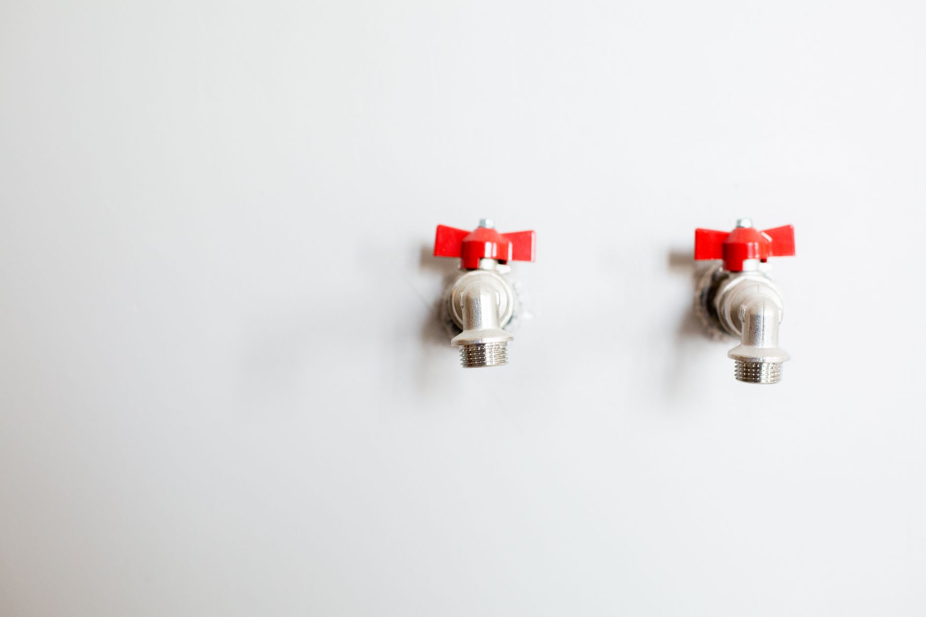 Two water valves on a white wall