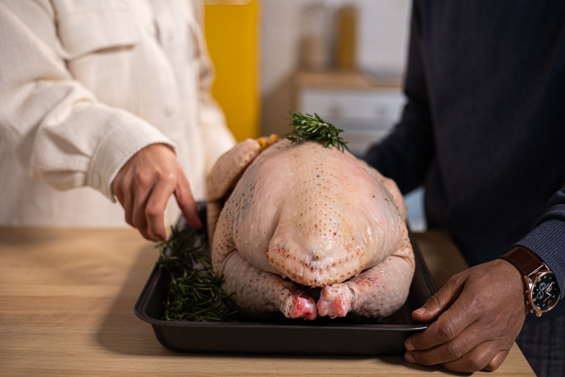 A raw turkey in a roasting pan