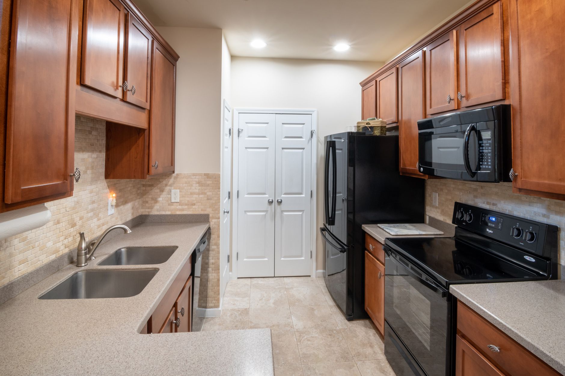 A kitchen with wood cabinets and black appliances