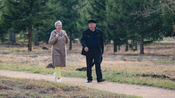 Best rollator walker: an older adult walking along a park path