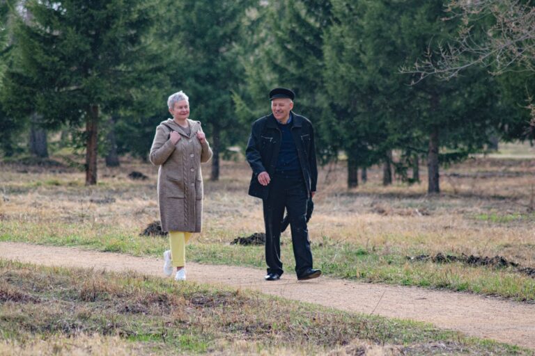 Best rollator walker: an older adult walking along a park path