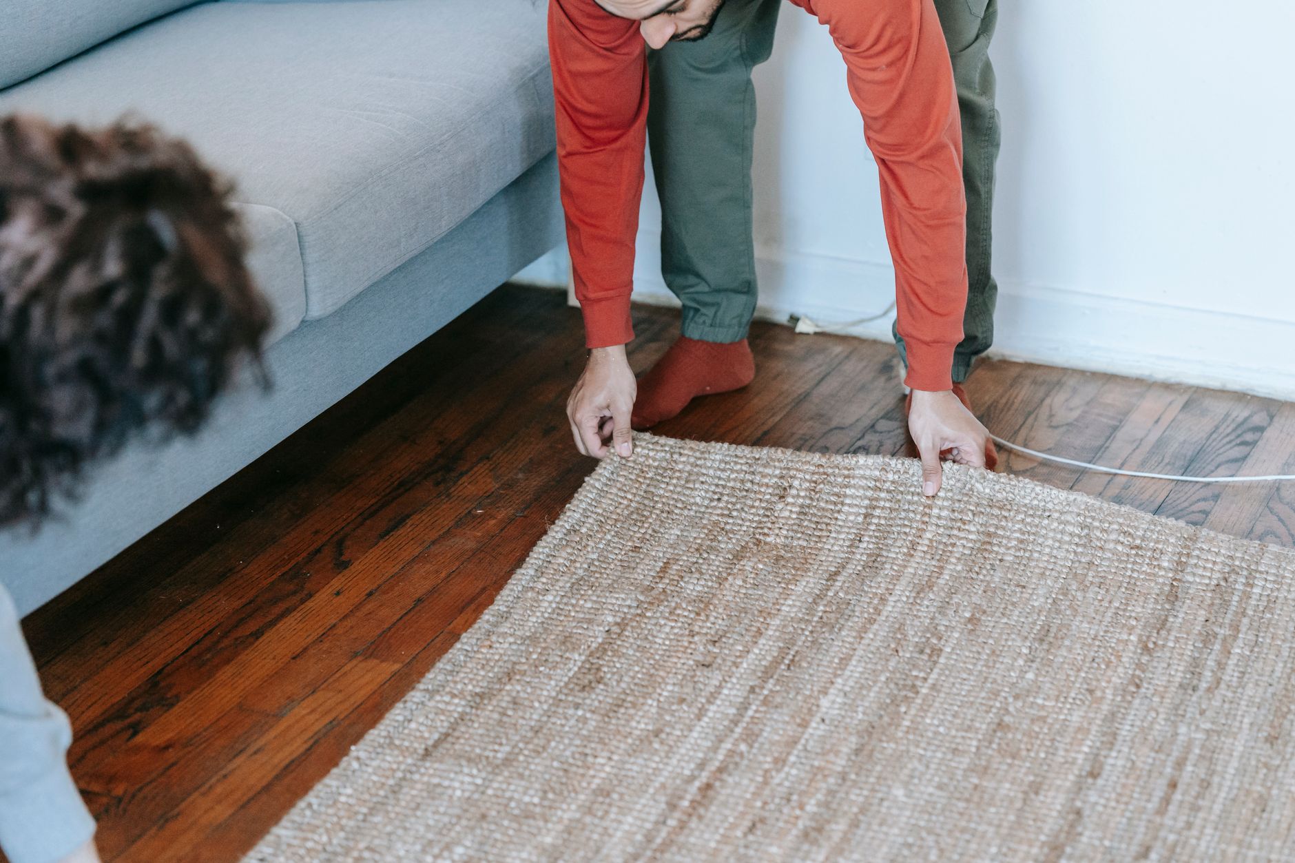 A living room with a rug on a wood floor