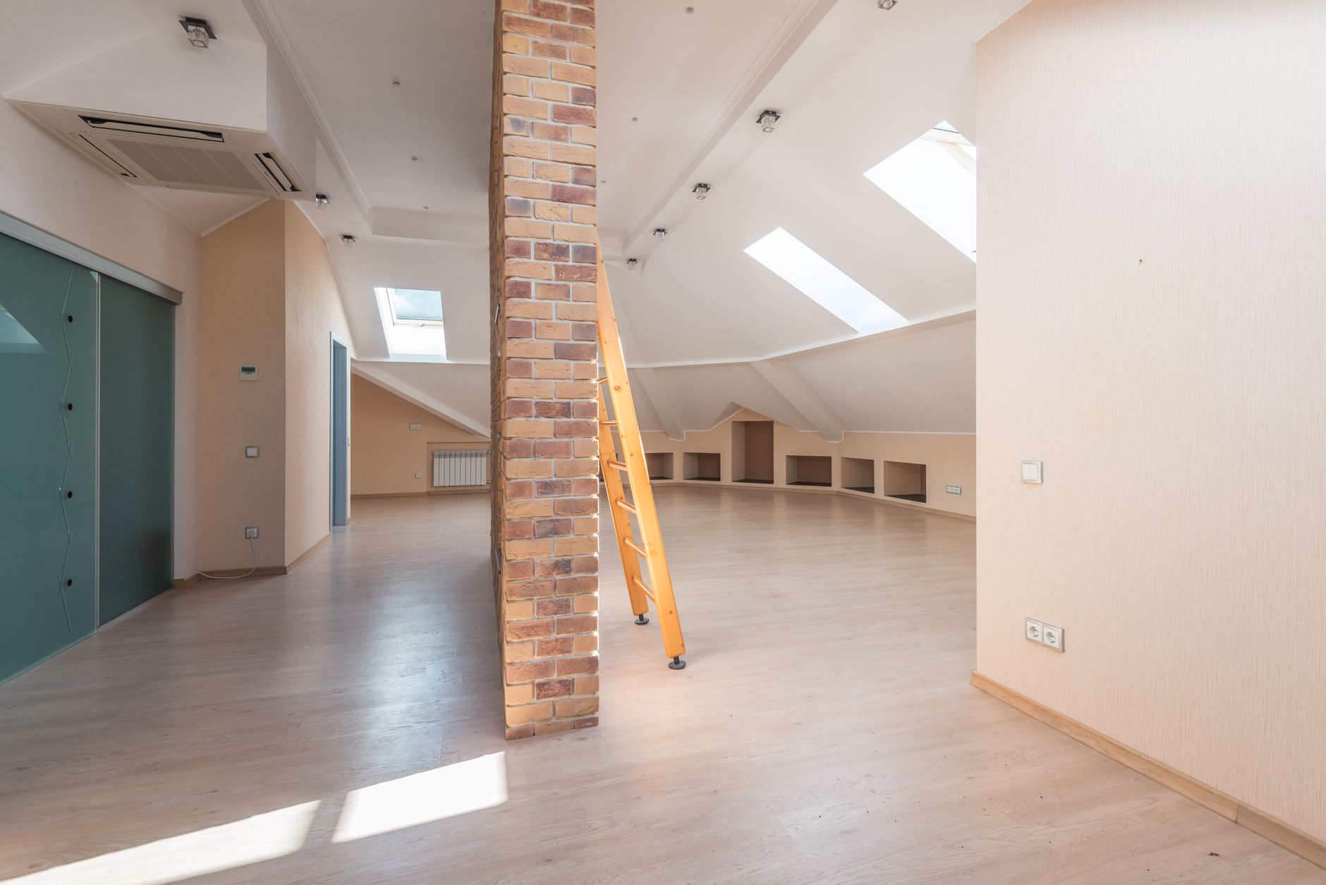 An empty attic room with skylights under a sloped roof