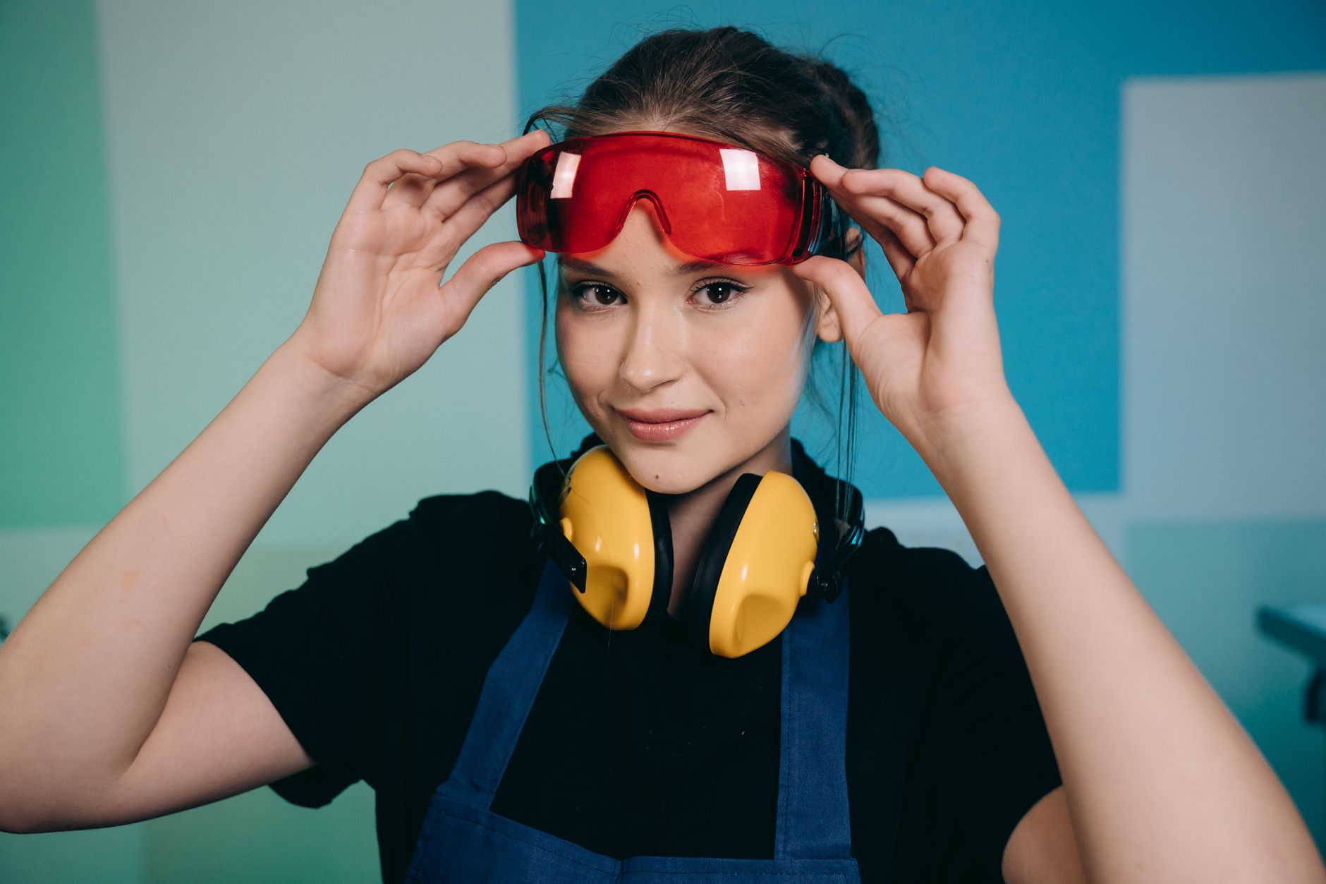 Best safety glasses: a woman putting on protective goggles
