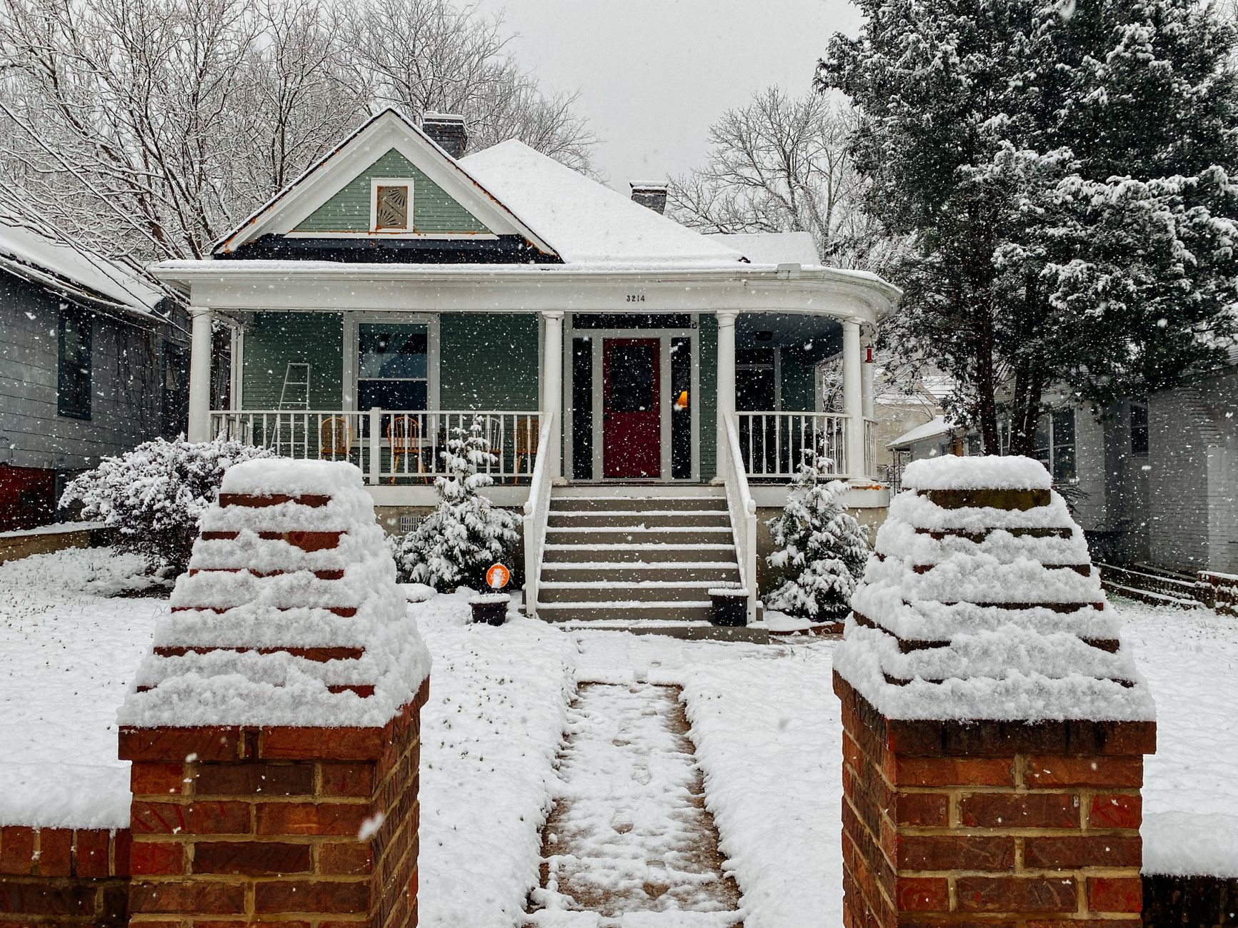 A snowy front walk leading to a porch