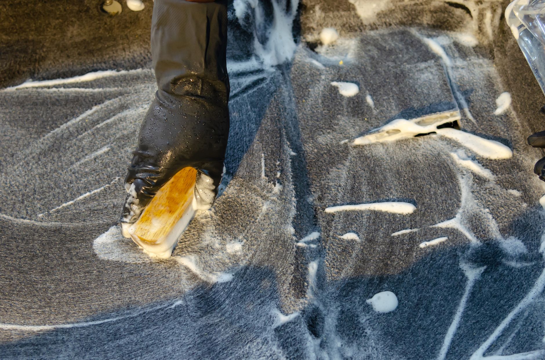 Best scrub brush: scrubbing a soapy rug with a brush
