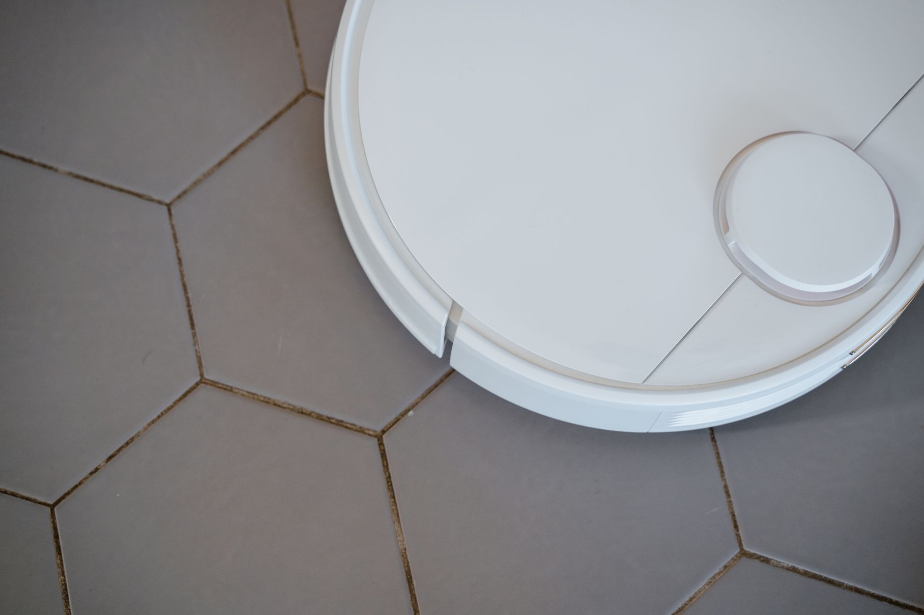 A robot vacuum on a hexagon tile floor