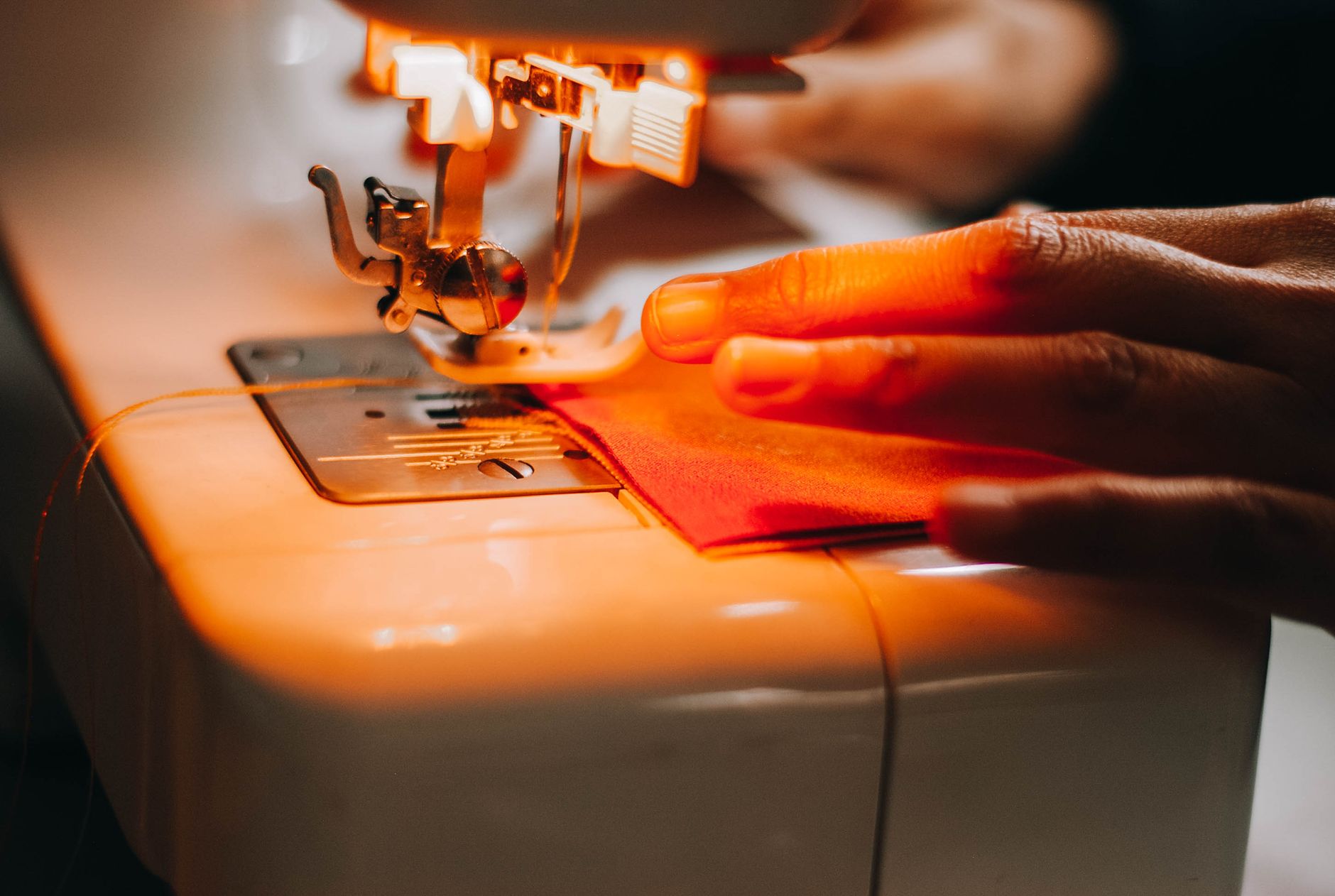 Hands sewing a piece of fabric