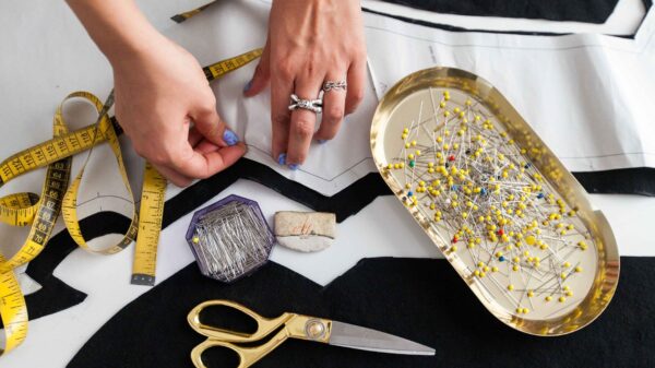 Pins, scissors and a tape measure on fabric