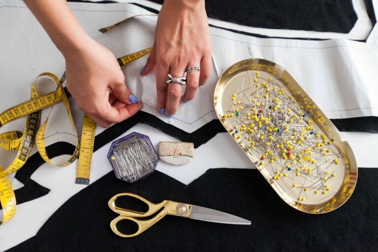 Pins, scissors and a tape measure on fabric