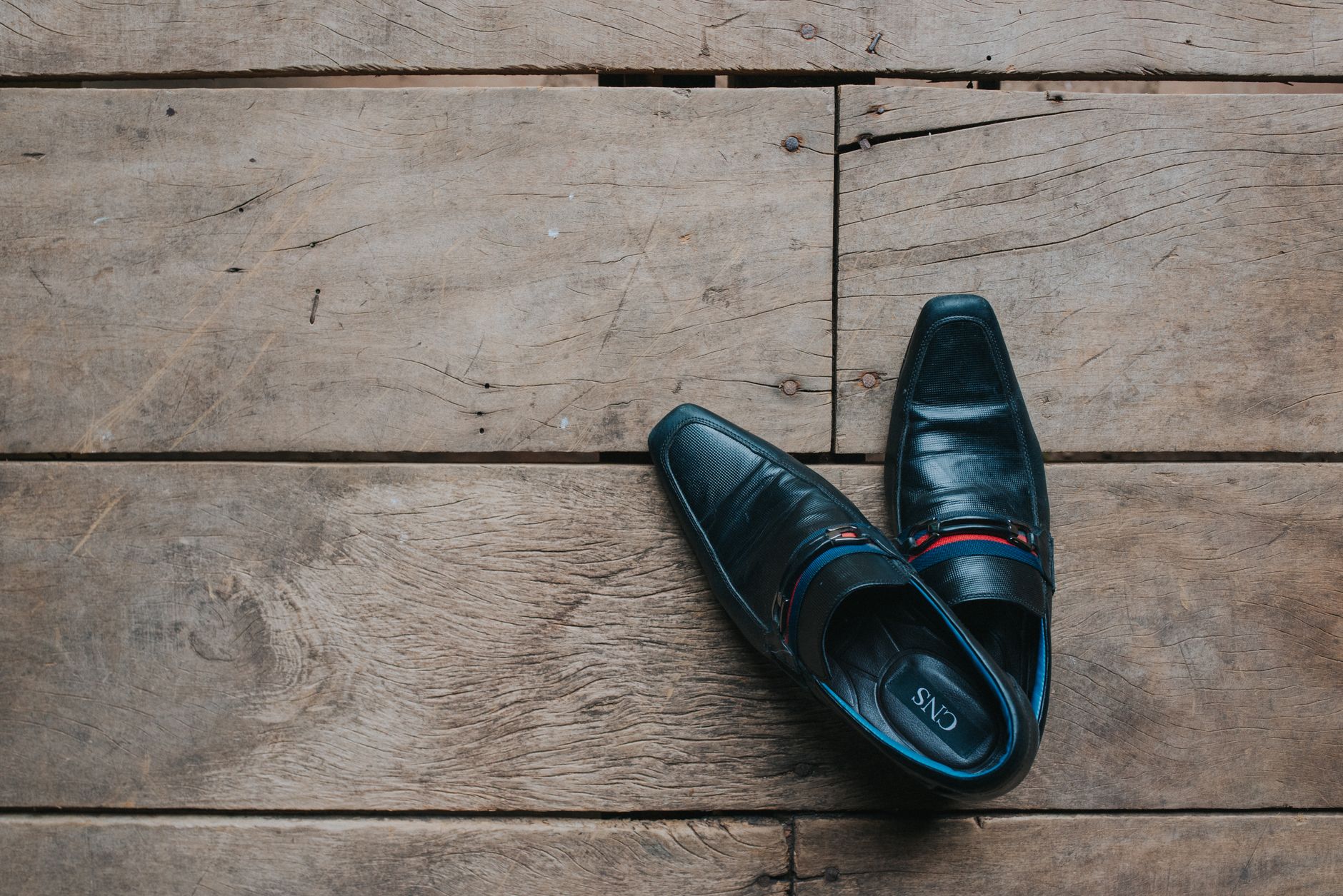 A pair of leather shoes on a wooden floor