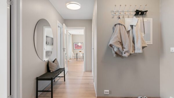 An entry hall with a bench, coat hooks and shoes