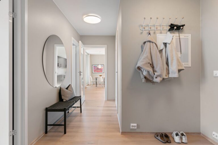 An entry hall with a bench, coat hooks and shoes