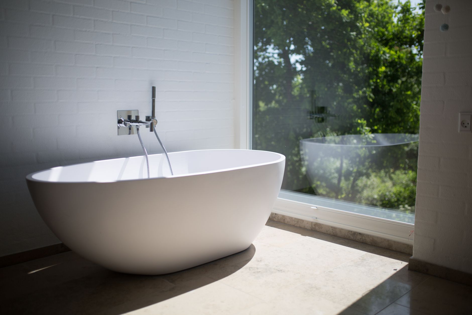 A freestanding tub by a large window