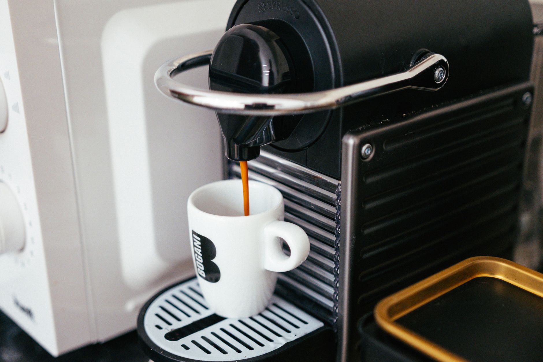 Best single serve coffee maker: a pod machine brewing into a mug