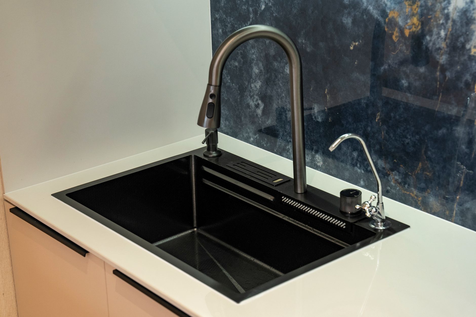 A black kitchen sink with a pull-down faucet