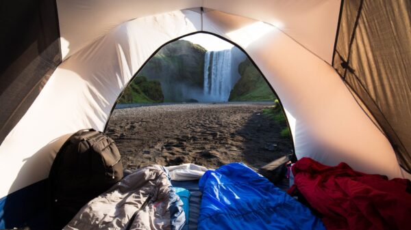 Sleeping bags inside a tent facing a waterfall