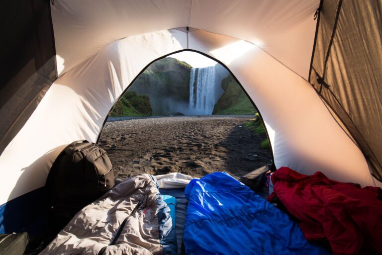Sleeping bags inside a tent facing a waterfall