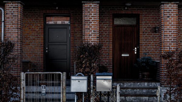Two brick row-house front doors behind a low gate