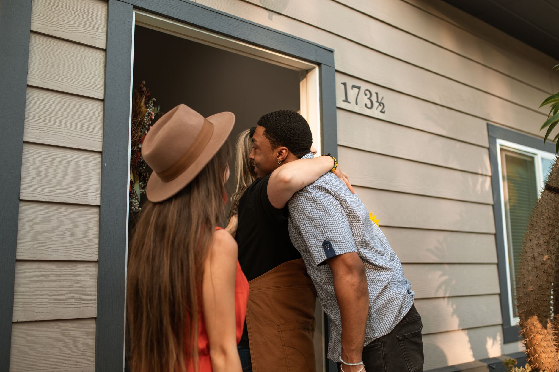 A couple embracing at the open front door of a house