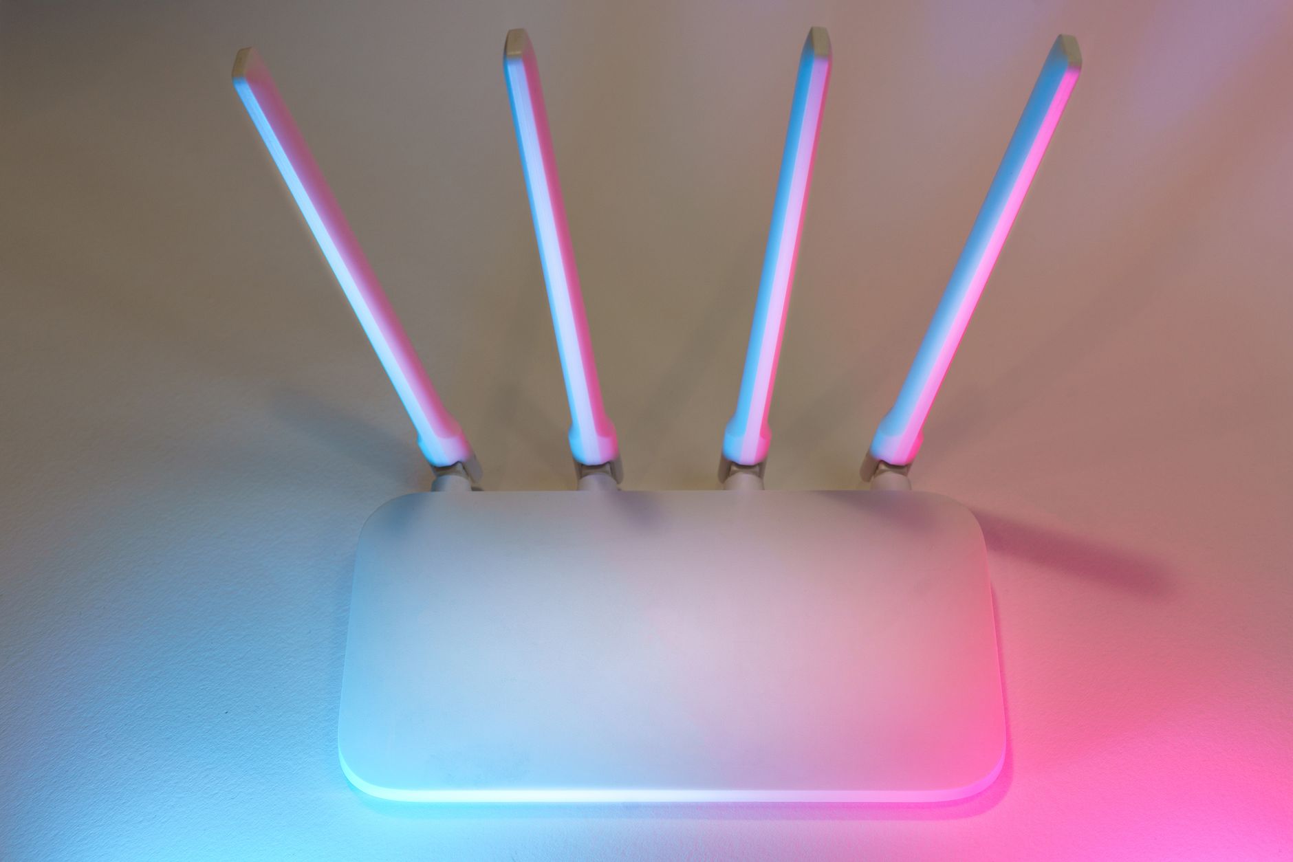 A white Wi-Fi router with four lit antennas