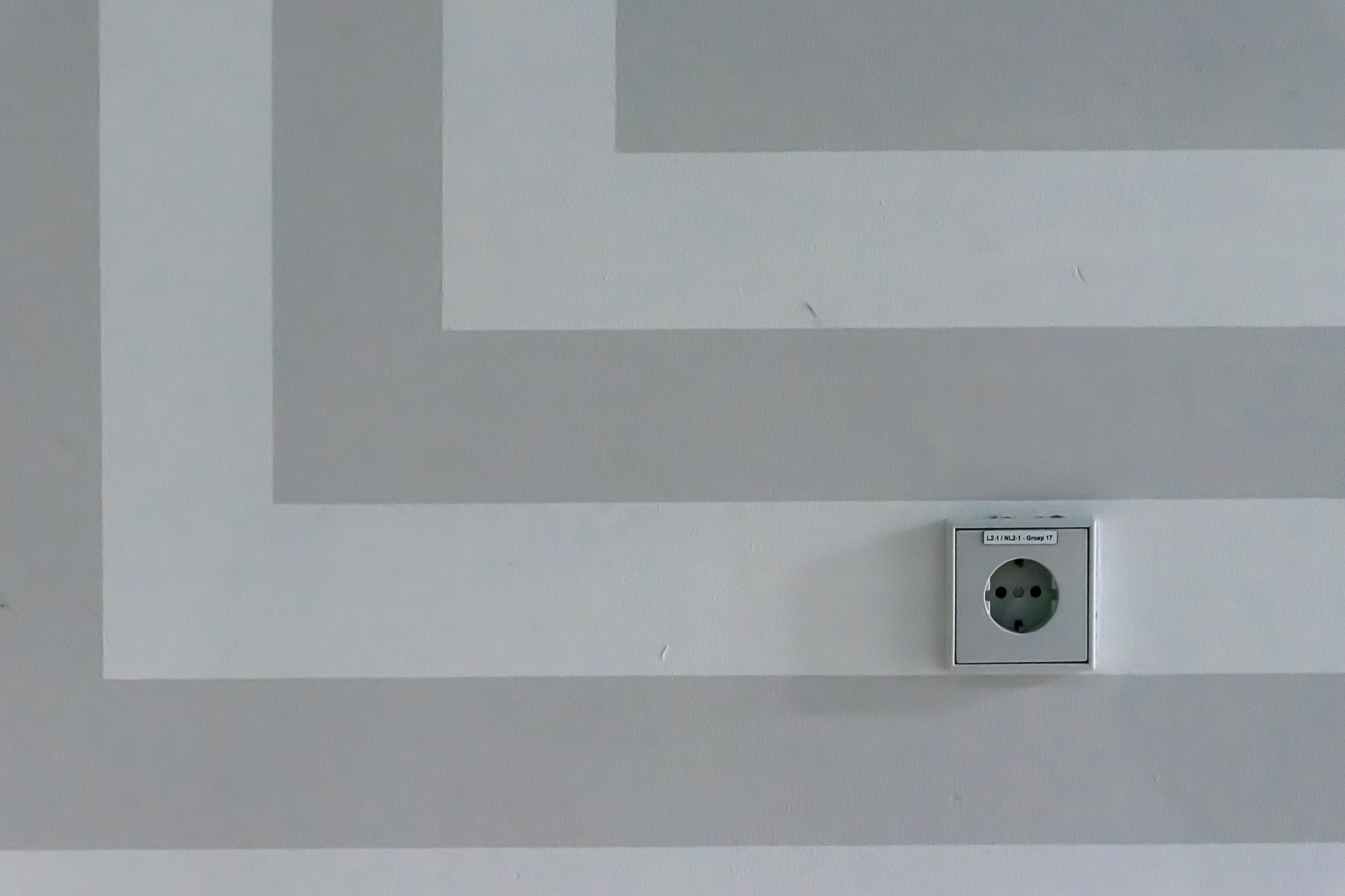 A wall outlet on a gray painted wall