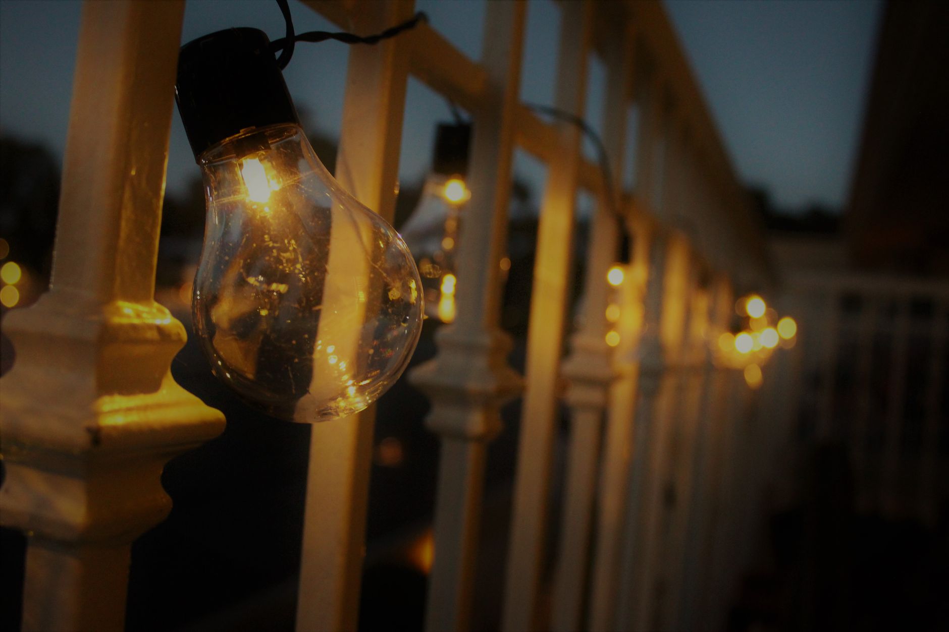 String lights glowing on a balcony railing