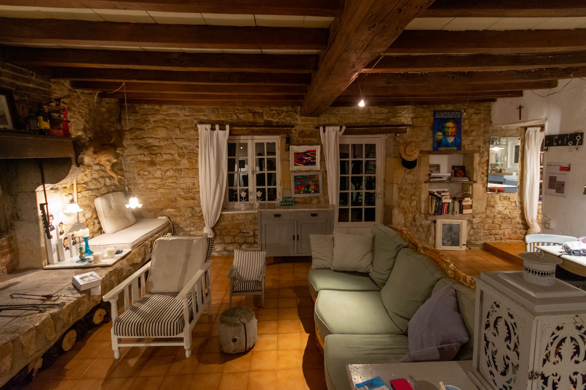 A cozy living room with stone walls and lamps