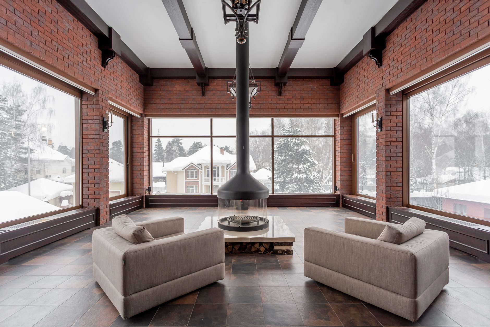 A living room with a fireplace and snowy views