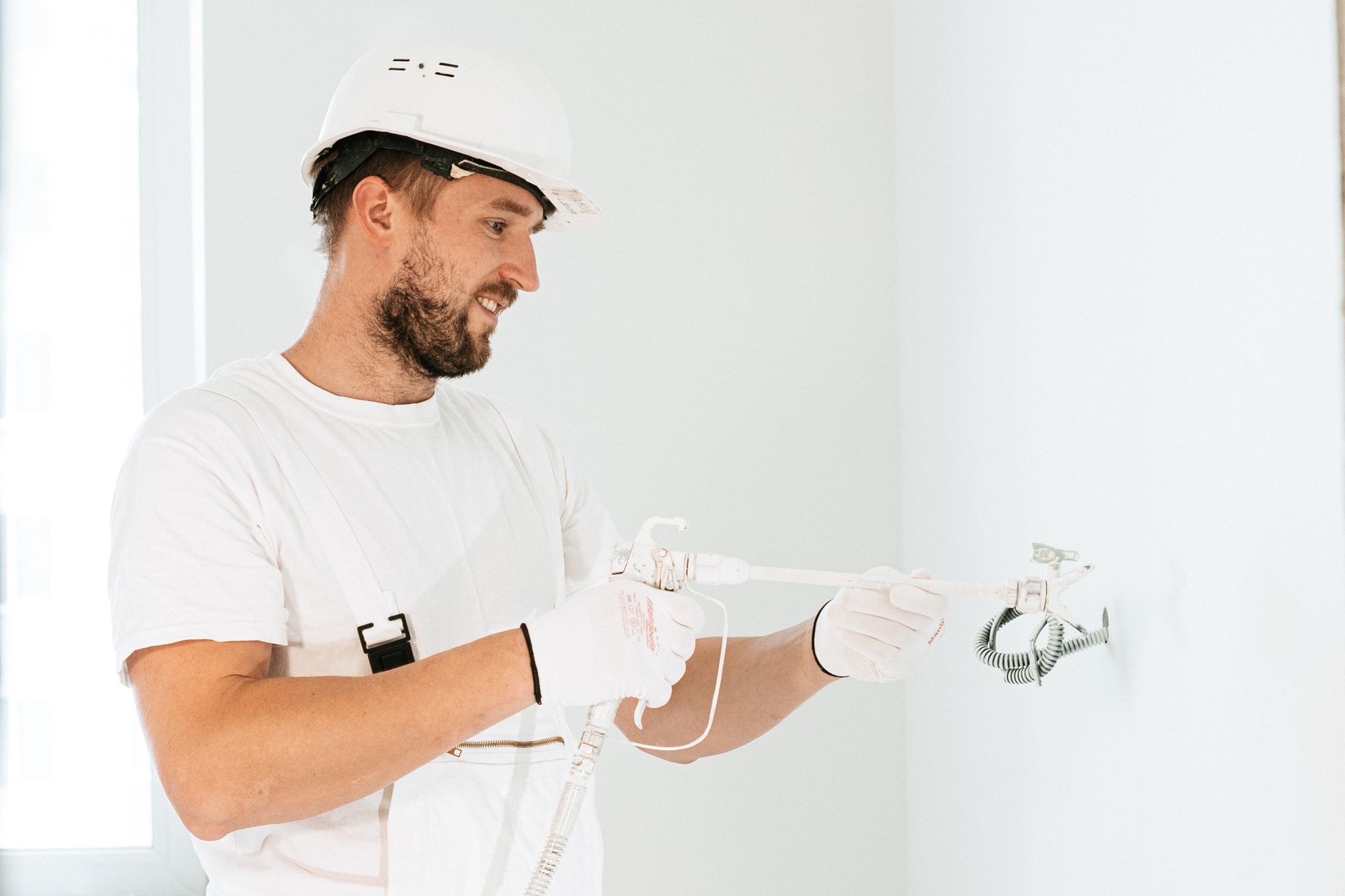 A worker sealing a wall indoors