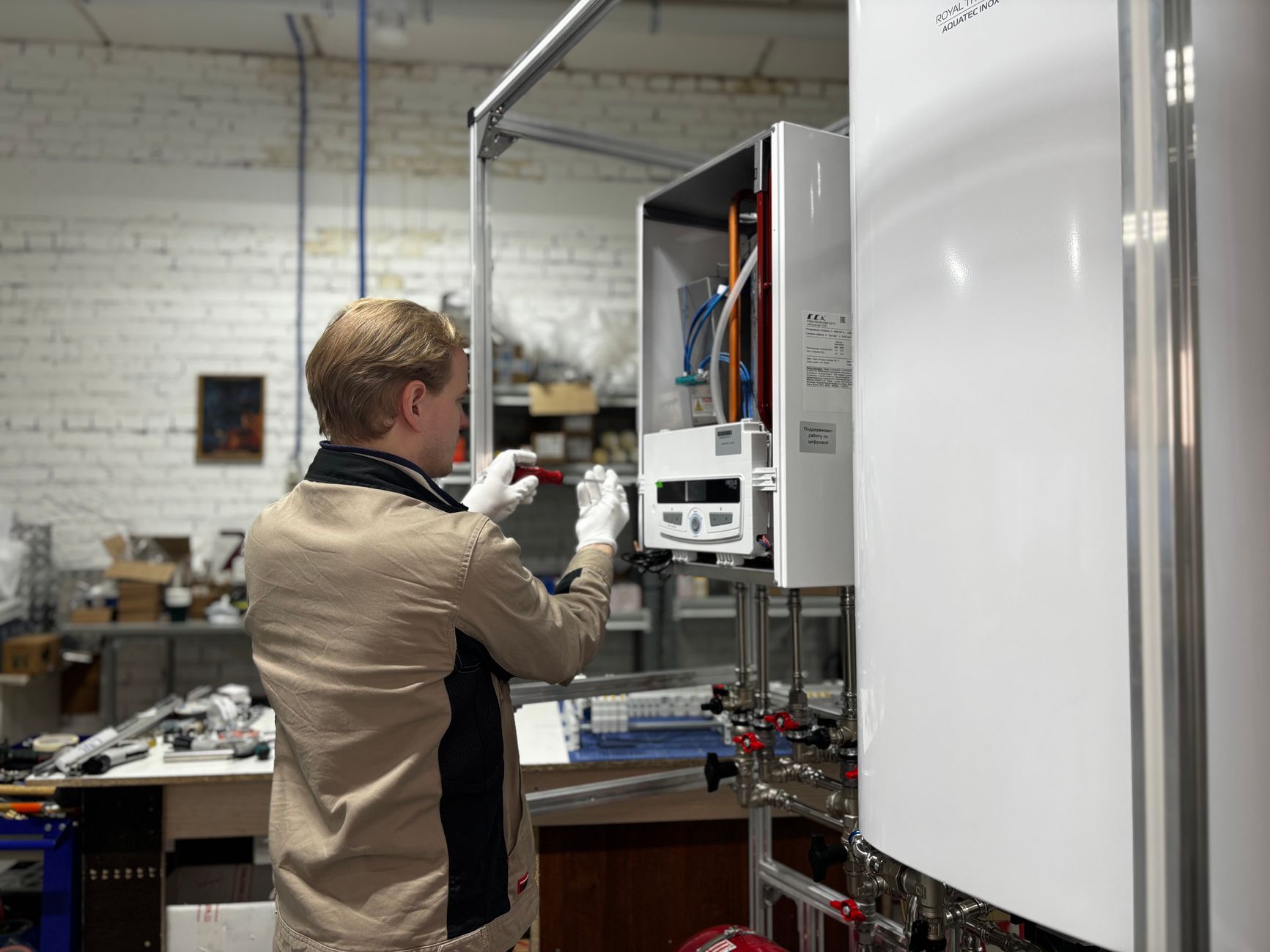 A technician working on a wall-mounted water heater