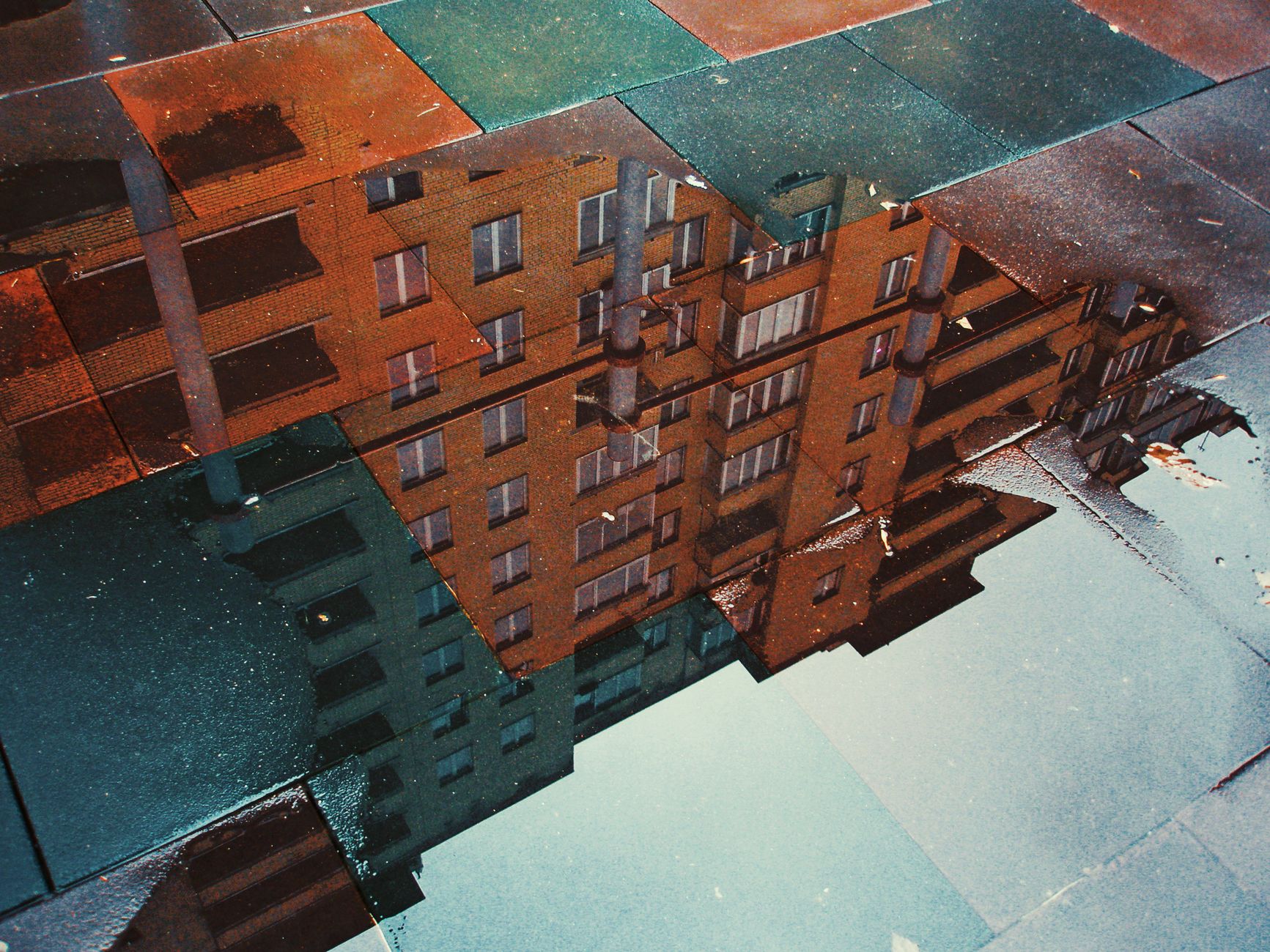 A building reflected in a puddle of water on a floor