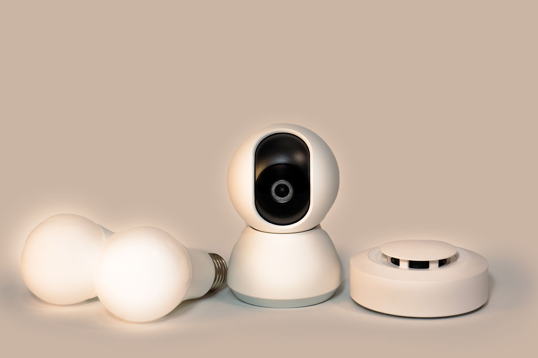 Best smoke detector: a smoke detector beside smart bulbs and a camera