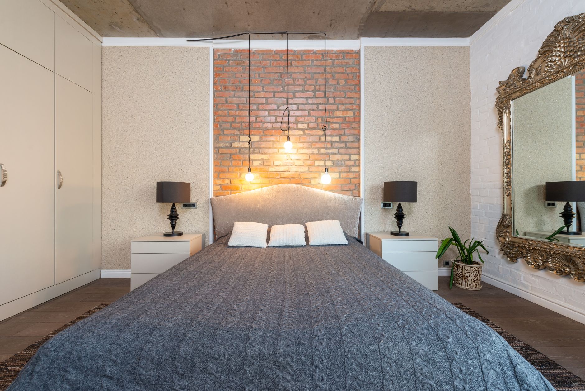 A bedroom with a brick accent wall